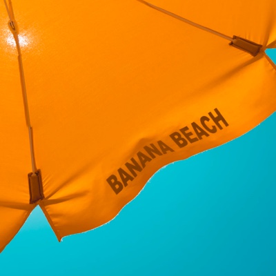 Underside photo of a yellow umbrella contrasting bright blue sky